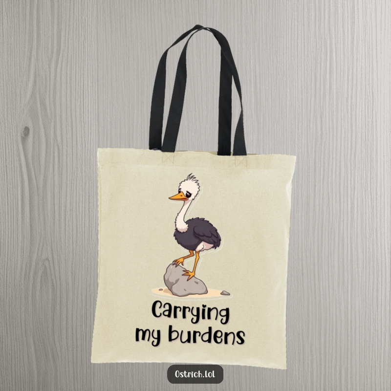 Funny tote bag with a wobbly ostrich character struggling to balance a small rock, perfect for carrying groceries with humor.
